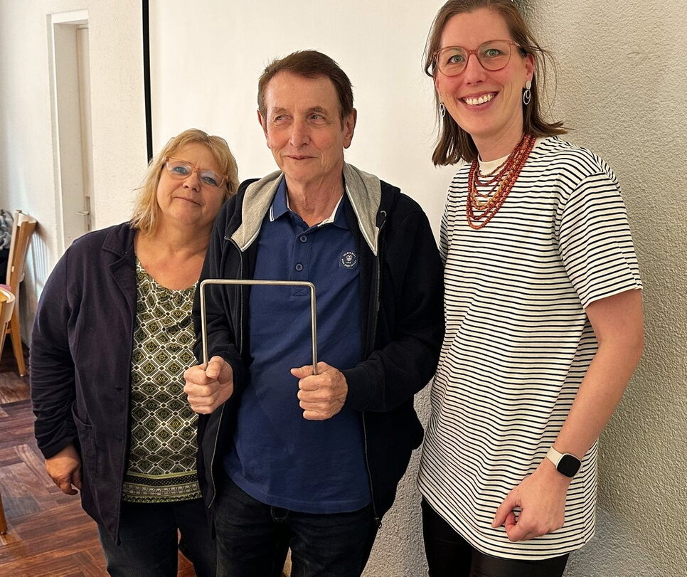 Das Foto zeigt die Übergabe des ersten Törchens durch die DCV-Präsidentin Sarah Böse (re.) und die DCV-Geschäftsführerin Sabine Schmidt-Hess an den Vertreter des MGF Waldshut 1974, Karl-Heinz Gerwert.